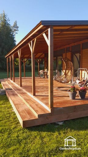 Pie mājas piebūvēta dabīgā koka veranda ar plašu, ar jumtu  pārklātu terasi - garden gazebo pergola