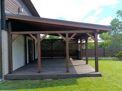 Tumši brūna koka mājai pievienota veranda ar jumtu – 4.8×6 m